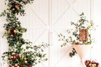 white barn doors with greenery and bright blooms are a lovely idea for a delicate spring or summer wedding