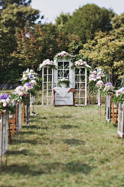 white frame doors with pastel and neutral blooms, greenery and a matching arrangement are a lovely idea for a wedding