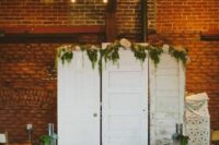 white shabby chic doors decorated with greenery and blush blooms are a lovely and relaxed wedding backdrop to rock