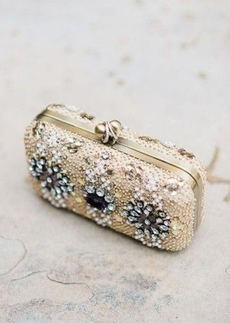 a beautiful heavily embellished clutch with large black blooms and crystals is a very refined solution for a bride
