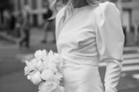 a beautiful mini dress with a high neckline and puff sleeves and a veil for an ultra-modern and very bold bridal look