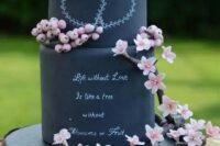 a black chalkboard wedding cake with chalking and a bit of pink blooms and berries is a spectacular idea for a spring wedding