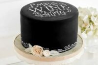 a black chalkboard wedding cake with chalking, with white and blush blooms is a lovely idea for a modern wedding