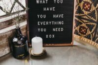 a black sign with a copper frame and a quote is a lovely decor idea for a wedding, it will fit a modern or boho celebration