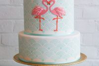 a blue patterned wedding cake with pink flamingos as decor is a lovely idea for a bright tropical wedding