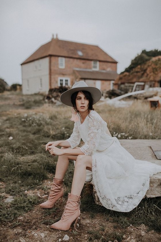 a boho lace a-line wedding dress with a high neckline, short sleeves, tan booties and a hat