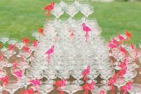 a champagne glass tower with pink flamingo toppers that mark glasses is  a very unusual and fun idea to try