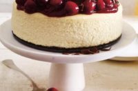 a cheesecake topped with milk chocolate shaves and fresh cherries will make everyone happy