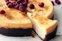 a creme brulee cheesecake topped with fresh raspberries is a creative take on a traditional dessert