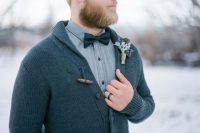 a dark grey cardigan, a grey shirt and a black bow tie for a relaxed winter groom look