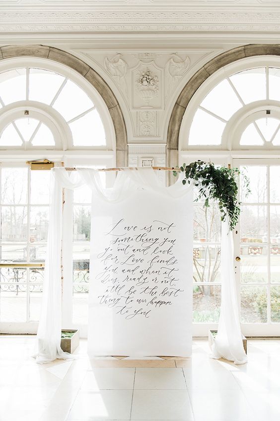 a dreamy wedding backdrop with a quote, white fabric, greenery is a lovely and very romantic idea for a wedding