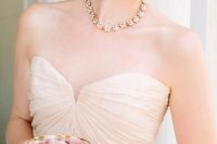a gold floral necklace likt this one plus a matching bracelet will give a delicate and chic touch to your bridal look