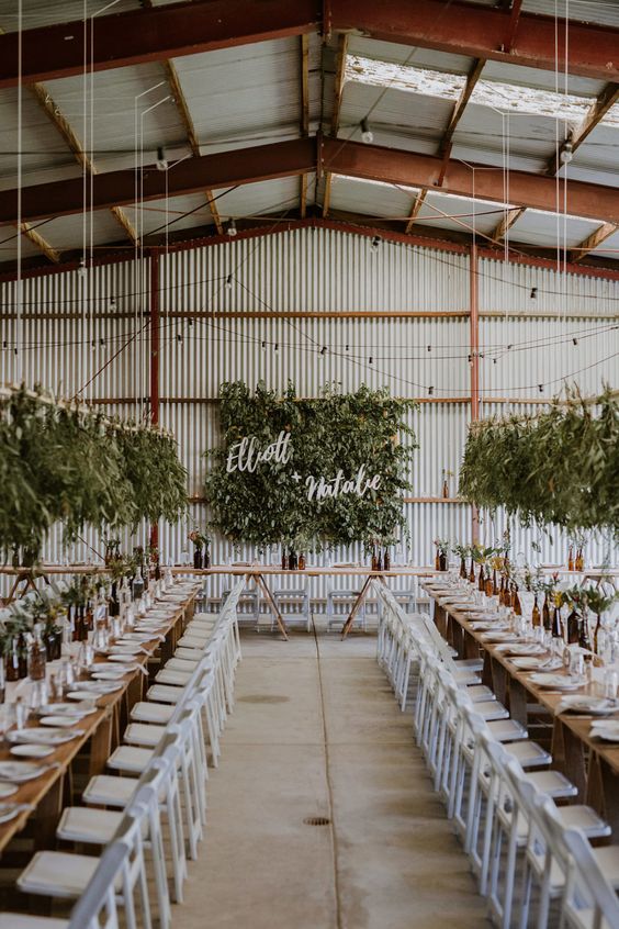 a greenery wall with calliraphy and overhead greenery installations that match create a fresh ambiencein the industrial venue