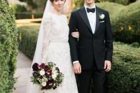 a high neckline long sleeve A-line wedding dress of textural lace and with a matching veil