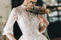 a jaw-dropping lace applique and embellished wedding ballgown with a high neckline and short sleeves plus a crown