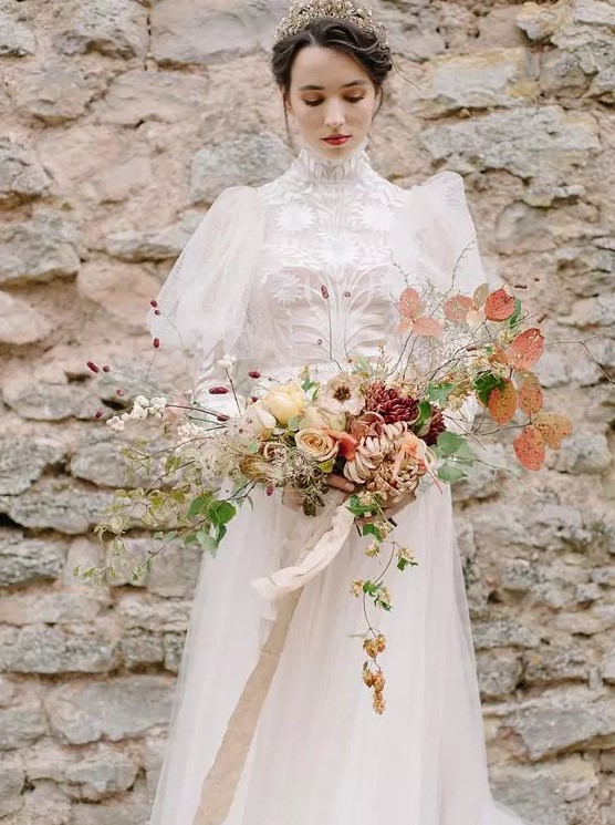 a jaw-dropping wedding dress with a lace turtleneck, Juliet sleeves, an embellished sash, a keyhole back and a gold and pearl headpiece just wows