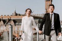 a lace A-line midi wedding dress with a high neckline and long sleeves plus white shoes for a city elopement