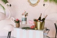 a lovely retro striped drink cart with tropical blooms, leaves and blush flamingos around is a super fun and creative idea to rock