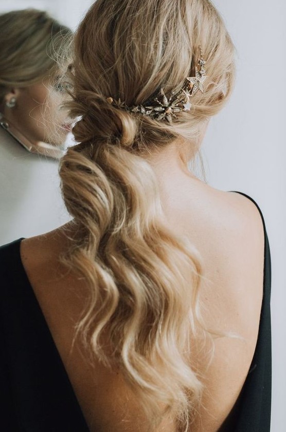 a low wavy ponytail with a messy top accented with a cool shiny star headcomb is a gorgeous idea