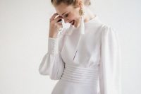 a modern take on a vintage wedding dress – a plain turtleneck Victorian-inspired wedding gown with long sleeves and tassel earrings
