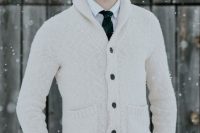 a monochromatic outfit with a white shirt, grey pants, a creamy cardigan and a tartan tie for a Christmas wedding