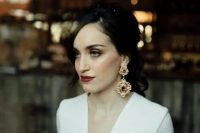 a moody bride rocking statement vintage earrings of gold and rubies and a matching deep burgundy lip