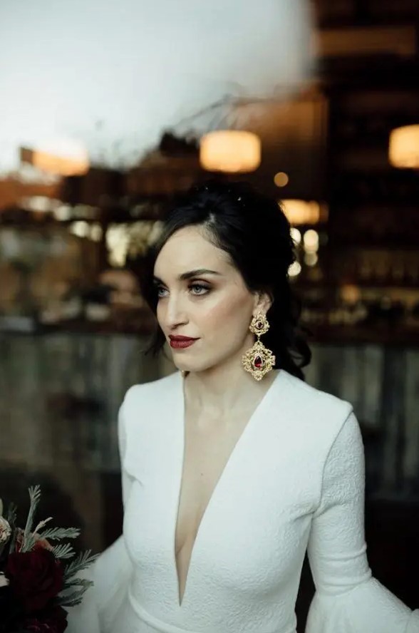 a moody bride rocking statement vintage earrings of gold and rubies and a matching deep burgundy lip