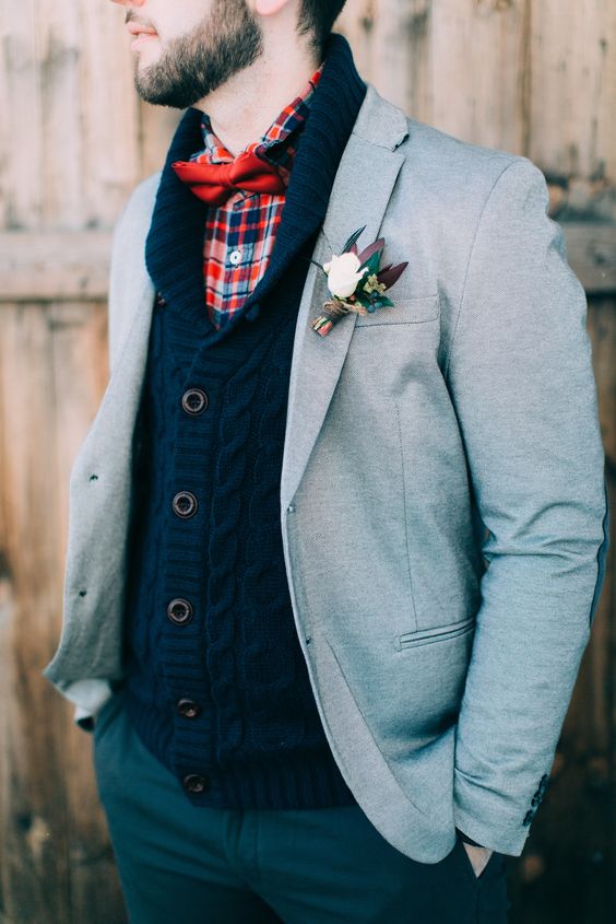 a navy cable knit cardigan, a plaid shirt with a red bow tie, a dove grey blazer for a cozy and wamr outfit