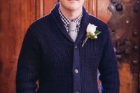 a navy gingham shirt under thick navy shawl cardigan and neutral pants for a mountain lodge wedding