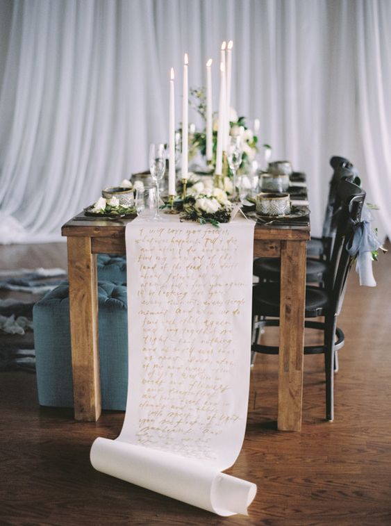 a refined wedding tablescape with a paper table runner with gold quotes is a chic and stylish idea that will make your reception stand out