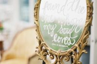 a round mirror in a gold ornated frame, with calligraphy is a cool decoration for a sophisticated wedding