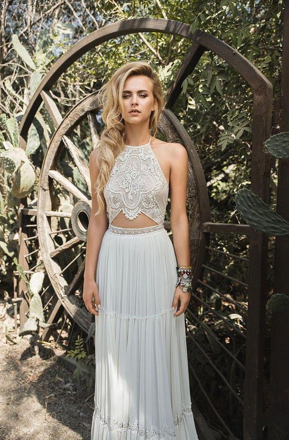 a sexy boho wedding dress with a lace embellished bodice with a halter neckline and a simple skirt plus an embellished waist