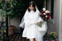 a short A-line wedding dress with a turtleneck and puff sleeves, black heels and a veil for a retro look