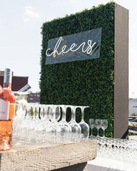 a simple boxwood wall with a neon sign will accent your wedding bar or dessert station and will make it more modern and chic