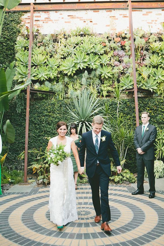 a super lush greenery wall, lots of statement plants around and succulents for a strong tropical feel at the wedding