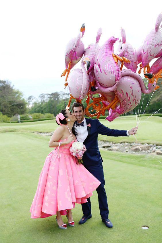 a whole bunch of pink flamingo balloons for wedding portraits and venue decor at a cool and super fun wedding
