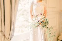 an art deco embellished wedding dress with a high neckline, fringe, short sleeves looks chic and bold