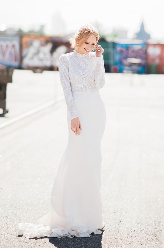 an elegant crepe wedding gown with a beaded and sequinned double layer lace top and pearl buttoned sleeves plus a train