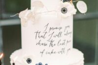 an exquisite white wedding cake with ruffles, a quote, white anemones, lunaria and berries is a very refined idea
