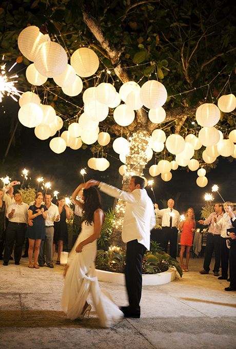 an outdoor dance floor with a living tree covered with string lights, paper lanterns all over for a lovely look