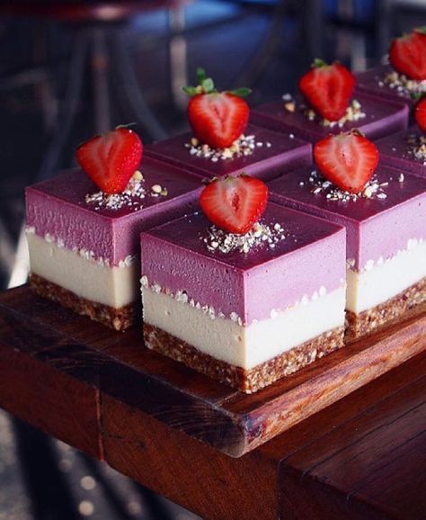 gorgeous looking blueberry cheesecakes with but bases and layering plus fresh strawberries on top