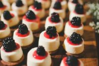 mini blackberry cheesecakes topped with fresh berry compote is a delicious treat for a wedding