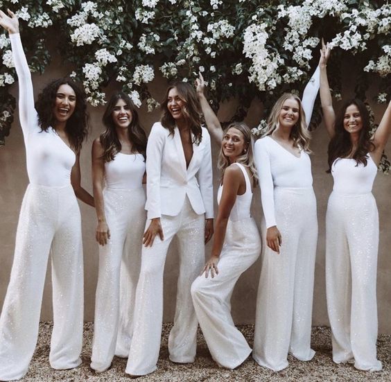 mismatching white pantsuits and jumpsuits with wideleg pants are a super cool idea for a modern bridal party