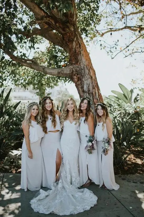 neutral summer bridesmaid looks with spaghetti strap crop tops and white maxi skirts with slits for a summer boho wedding