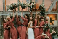 rust-colored jumpsuits with wideleg pants, nude shoes and greenery bouquets are a gerat combo for a boho wedding