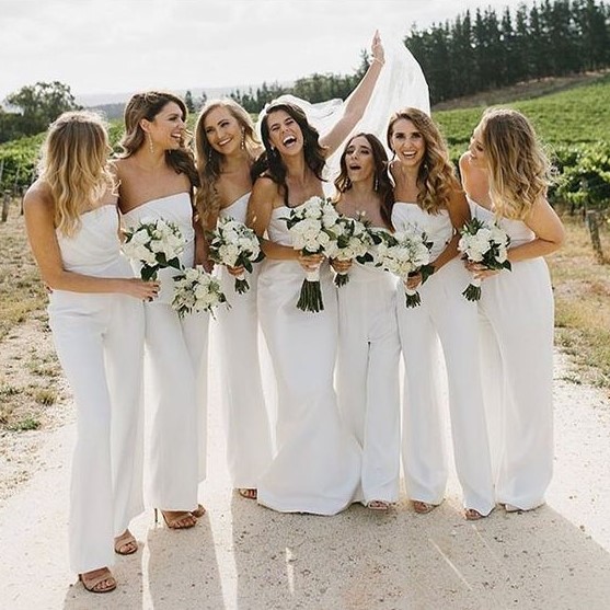 strapless white jumpsuits with draped bodices is a bold and chic idea for a summer wedding with a touch of edge