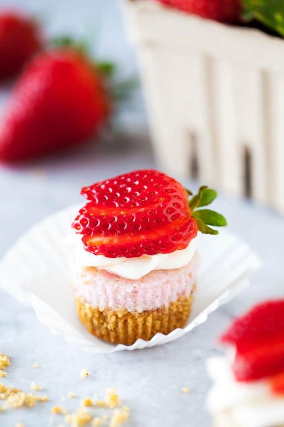 strawberry mini cheesecakes topped with whipped cream and fresh berries are amazing