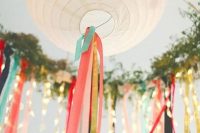 white paper lanterns decorated with colorful ribbon, with string lights and greenery are great for styling a wedding reception