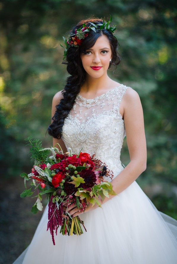 a beautiful Snow White bridal look with an embellished ballgown, a long braid with a floral and greenery crown plus a bold bouquet