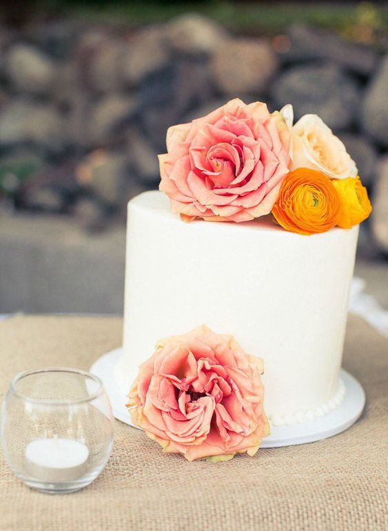 a beautiful buttercream one tier wedding cake topped with orange and pink blooms is a great idea for a bright summer wedding